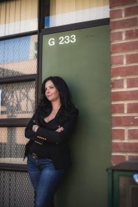 Journalism Department Chair Eleni Gastis stands in front of the renovated newsroom at Laney College room G-233. Photo by Saskia Hatvany