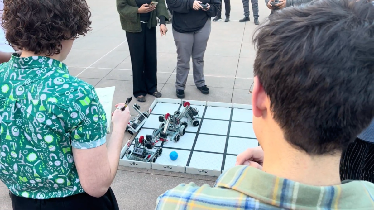 Laney Engineering Department Chair Mallory Barkdull tallies points as her students pit their soccer-playing robots against each other. The friendly tournament challenges contestants to learn design and coding skills through play.