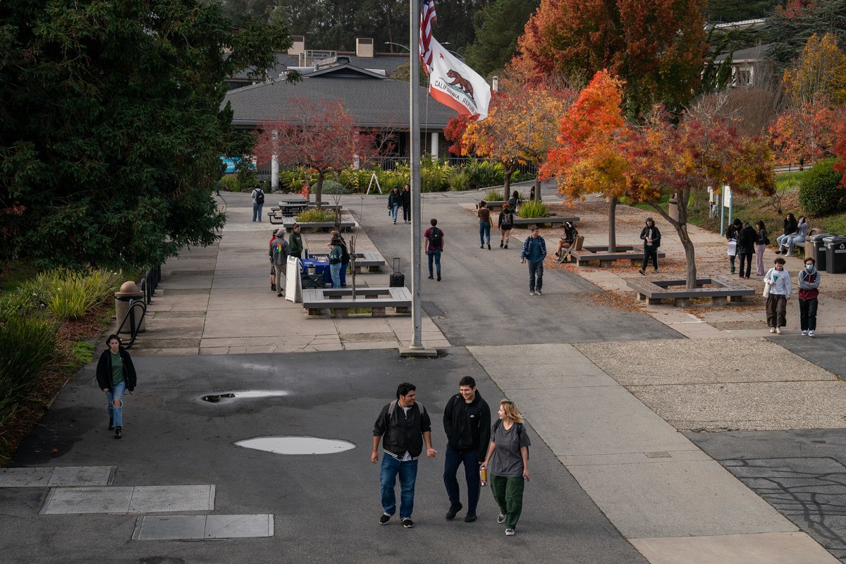 Students walk through campus at Cabrillo College in Aptos on Dec. 7, 2023. Photo by Loren Elliott for CalMatters