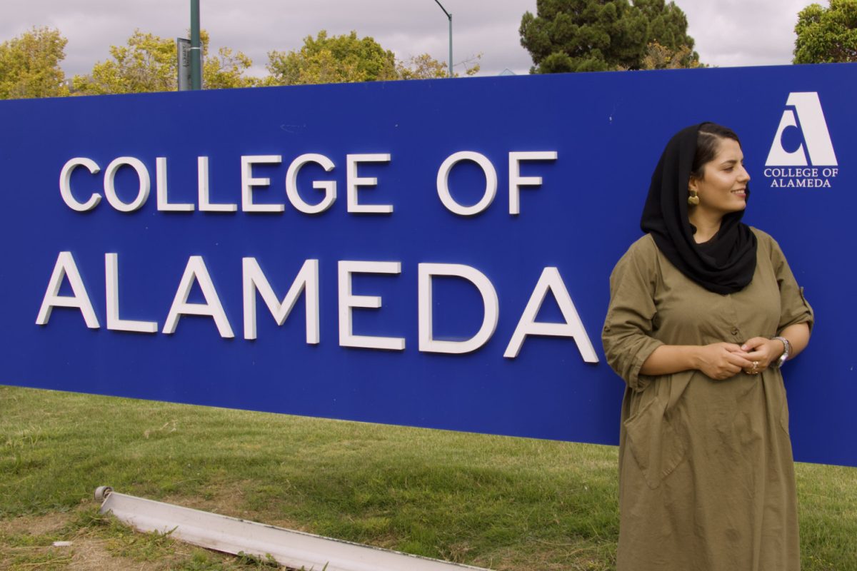 Mina Spasely, peer mentor for SALAAM learning community and nursing major at College of Alameda, poses in front of the sign for the college. SALAAM aims to uplift CoA students from Arab, Southwest Asian and North African diasporic communities.